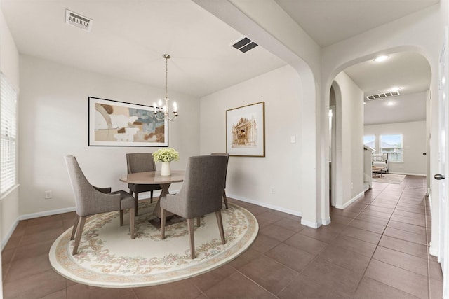 dining room featuring arched walkways, baseboards, visible vents, and a chandelier