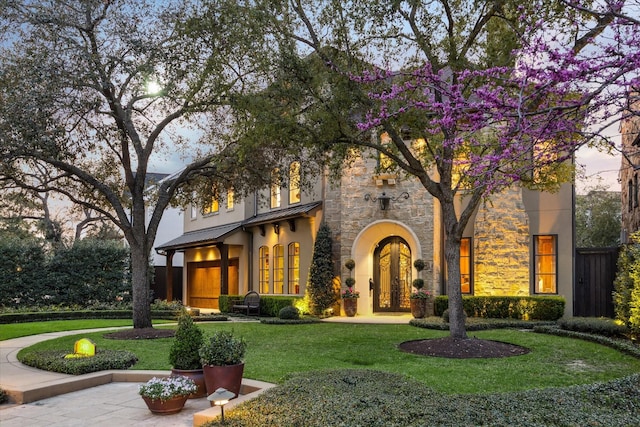 3410 Banbury Pl, Houston, TX 77027 - view of front of property featuring a front lawn, french doors, stucco siding, a standing seam roof, and metal roof