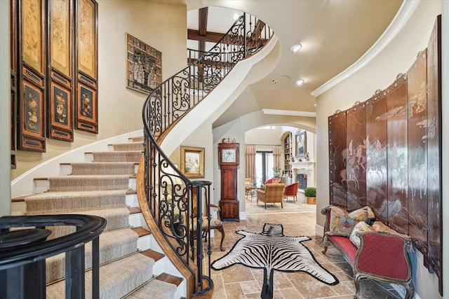 3410 Banbury Pl, Houston, TX 77027 - foyer featuring a high ceiling, arched walkways, recessed lighting, ornamental molding, and stairway