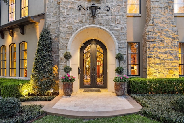3410 Banbury Pl, Houston, TX 77027 - view of exterior entry featuring stucco siding, french doors, and stone siding