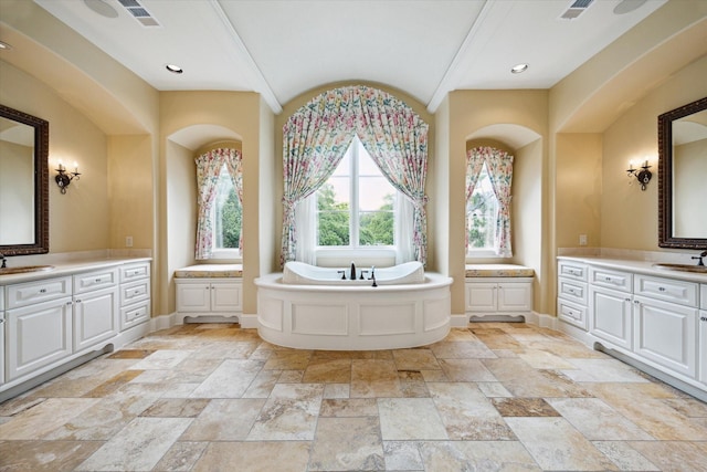 3410 Banbury Pl, Houston, TX 77027 - bathroom featuring a bath, visible vents, two vanities, a sink, and stone tile floors