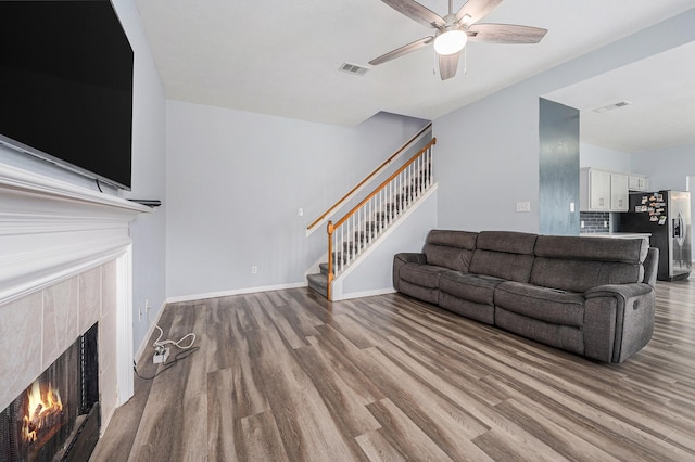 13134 Durbridge Trail Dr, Houston, TX 77065 - living area featuring visible vents, wood finished floors, a tile fireplace, and stairs