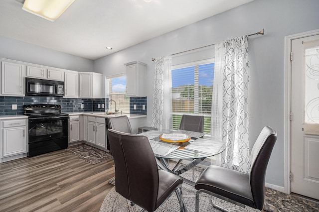 13134 Durbridge Trail Dr, Houston, TX 77065 - kitchen with dark wood finished floors, tasteful backsplash, black appliances, light countertops, and a sink