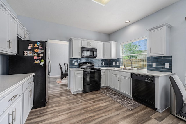 13134 Durbridge Trail Dr, Houston, TX 77065 - kitchen with light countertops, light wood finished floors, a sink, and black appliances