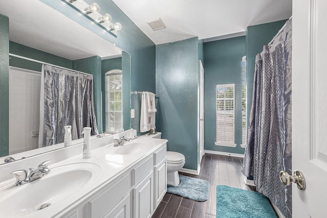 13134 Durbridge Trail Dr, Houston, TX 77065 - full bathroom with visible vents, a sink, toilet, and wood tiled floor