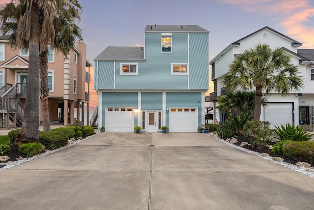 coastal inspired home with concrete driveway and an attached garage