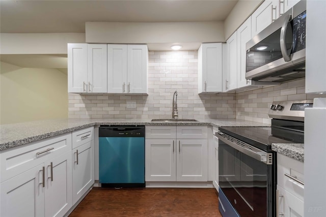 12046 Beechnut St, Houston, TX 77072 - kitchen featuring appliances with stainless steel finishes, light stone counters, white cabinetry, decorative backsplash, and a sink