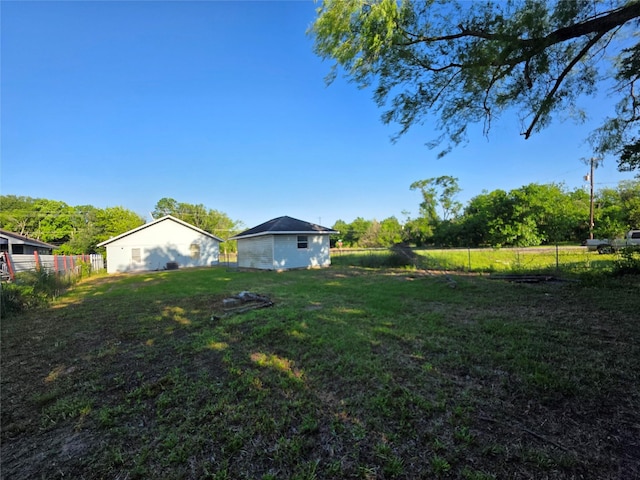 view of yard featuring fence and an outbuilding