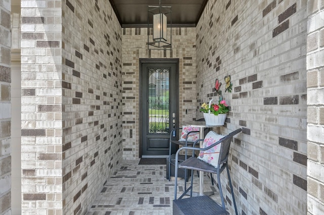 entrance to property featuring brick siding