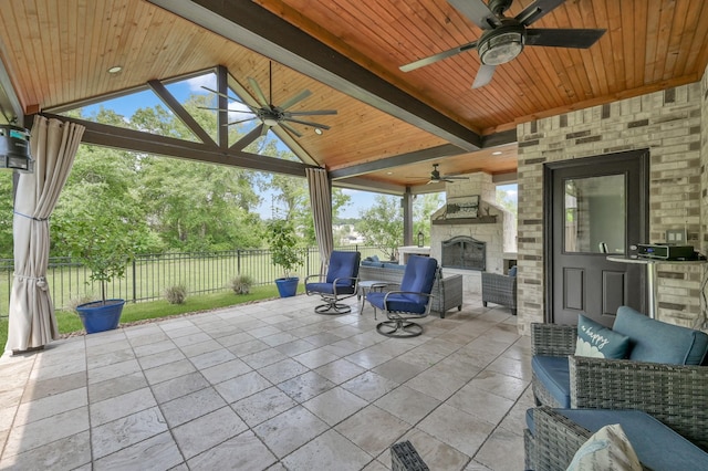 view of patio featuring an outdoor kitchen, a ceiling fan, fence, an outdoor living space with a fireplace, and a gazebo