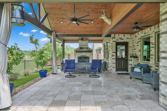 view of patio featuring an outdoor living space with a fireplace, fence, and a ceiling fan