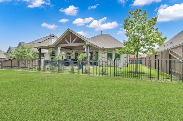 back of property with a yard, fence, and brick siding