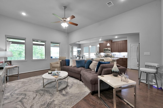 living area with plenty of natural light, visible vents, dark wood-style flooring, and ceiling fan