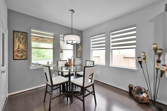 dining space featuring dark wood finished floors and baseboards