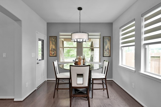 dining area with baseboards, dark wood-style floors, and a notable chandelier