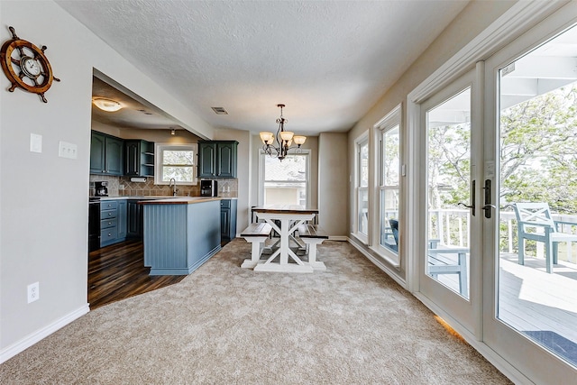 dining area with carpet, a notable chandelier, baseboards, and visible vents