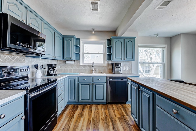 kitchen featuring a textured ceiling, dishwasher, stainless steel electric stove, and open shelves