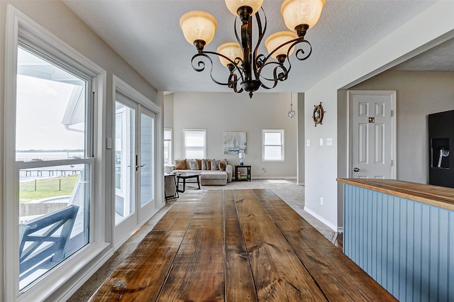 dining area with baseboards and an inviting chandelier