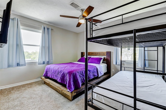bedroom featuring visible vents, baseboards, ceiling fan, a textured ceiling, and carpet flooring