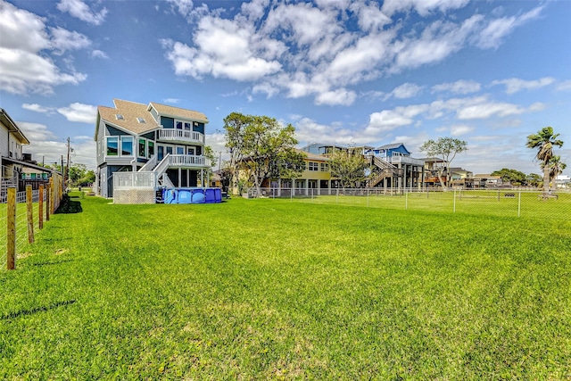 view of yard with stairs, a balcony, and a fenced backyard