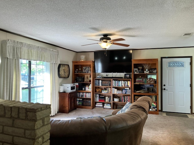 living room featuring a textured ceiling, a ceiling fan, visible vents, and carpet floors
