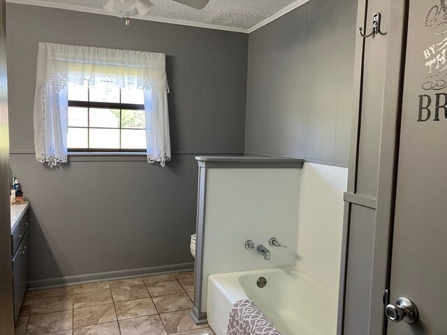 full bathroom with ornamental molding, toilet, a ceiling fan, a tub to relax in, and vanity