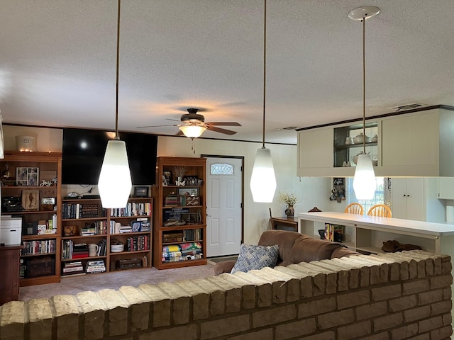 living area featuring a textured ceiling and ceiling fan