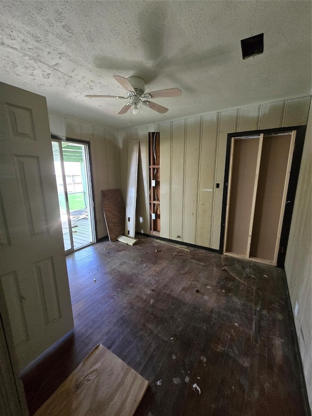 unfurnished bedroom with access to exterior, ceiling fan, a textured ceiling, and wood-type flooring