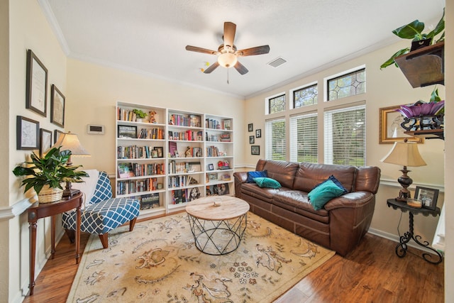sitting room featuring visible vents, a ceiling fan, ornamental molding, and wood finished floors