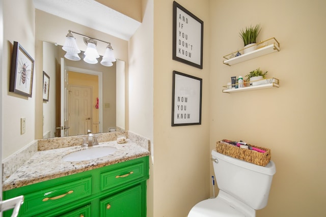 bathroom with toilet, an inviting chandelier, and vanity