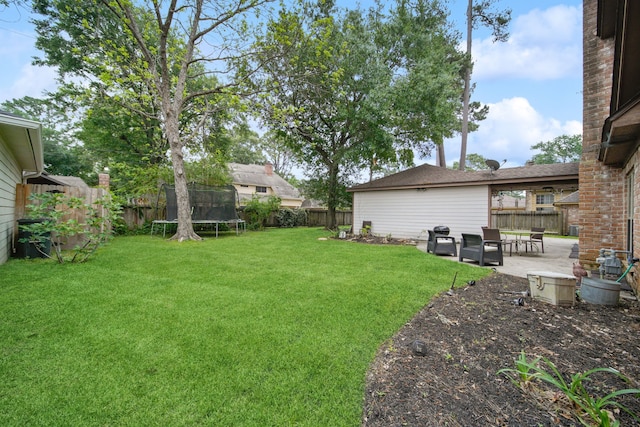 view of yard featuring a trampoline, a patio area, and a fenced backyard