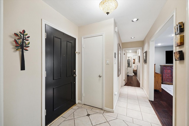 foyer with recessed lighting, light tile patterned floors, and baseboards