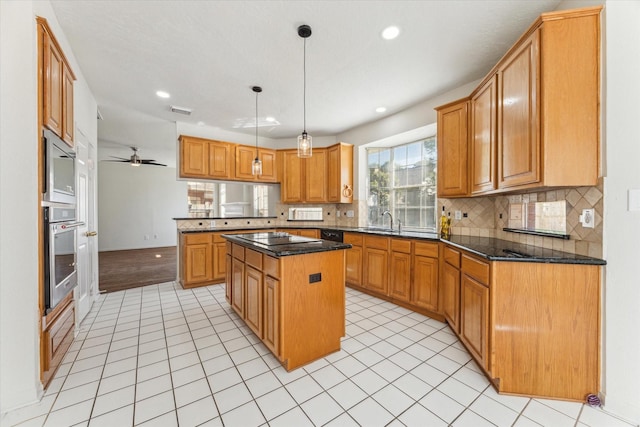 kitchen featuring a peninsula, backsplash, a kitchen island, visible vents, and stainless steel appliances