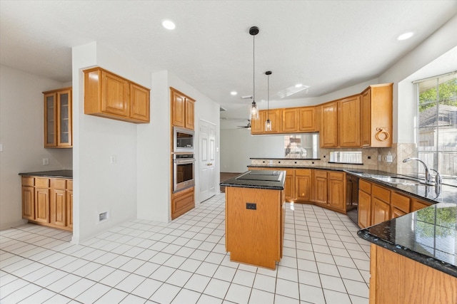 kitchen featuring a peninsula, light tile patterned flooring, black appliances, a kitchen island, and a sink
