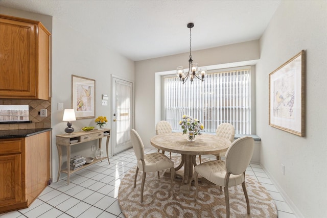 dining room with baseboards, an inviting chandelier, and light tile patterned flooring