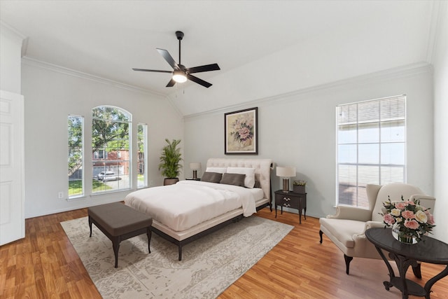 bedroom with light wood-style flooring, ornamental molding, a ceiling fan, and lofted ceiling