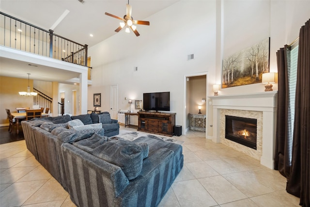 122 Verismo Ct, Montgomery, TX 77316 - living room with a high ceiling, light tile patterned flooring, visible vents, a tile fireplace, and ceiling fan with notable chandelier
