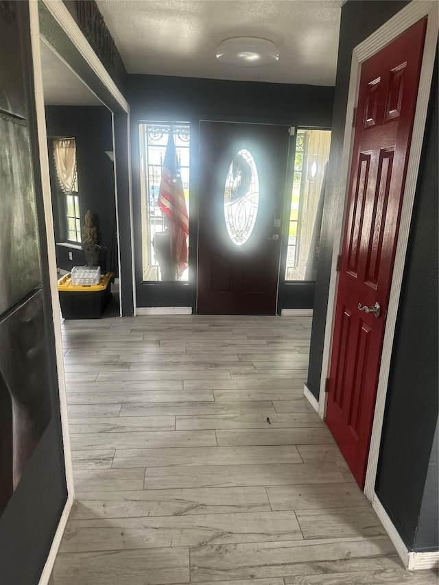 entrance foyer with wood finished floors and a textured ceiling