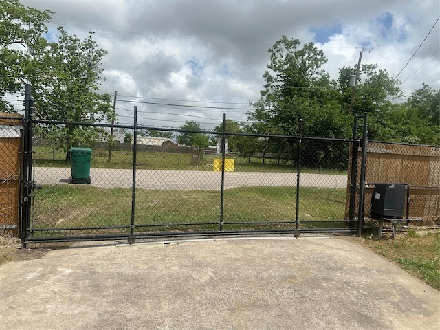 view of gate featuring a lawn and fence