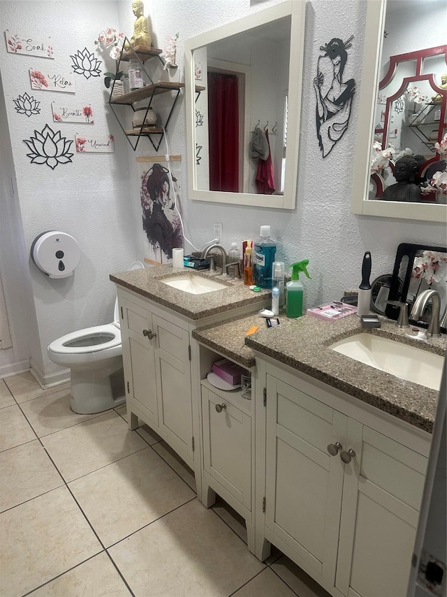 bathroom with tile patterned flooring, toilet, and a sink