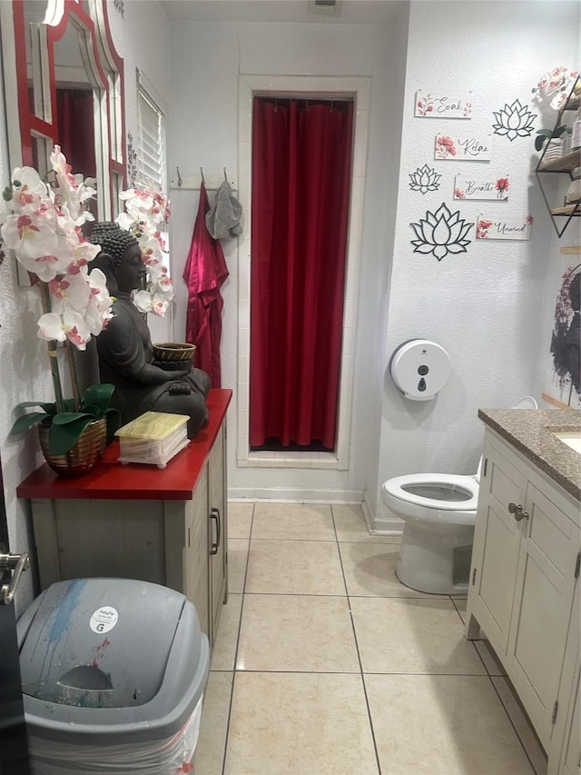 full bathroom featuring a shower stall, toilet, vanity, and tile patterned floors