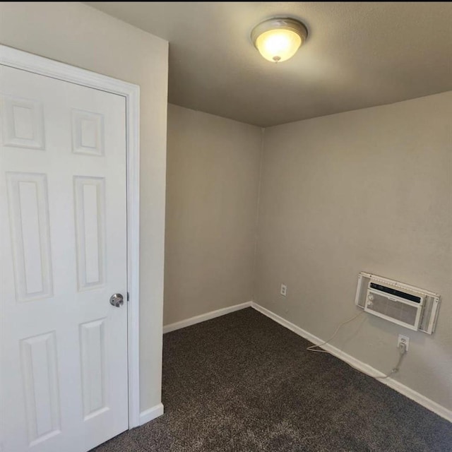 unfurnished room with dark colored carpet, a wall mounted AC, and baseboards