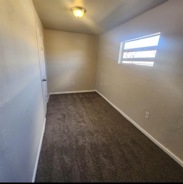 unfurnished room featuring carpet and baseboards
