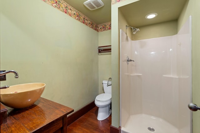 full bath featuring a walk in shower, wood finished floors, a sink, and visible vents