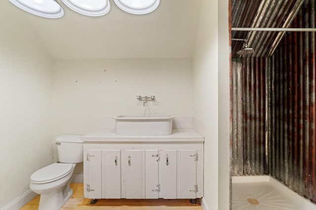 full bath with toilet, a walk in shower, vanity, and baseboards