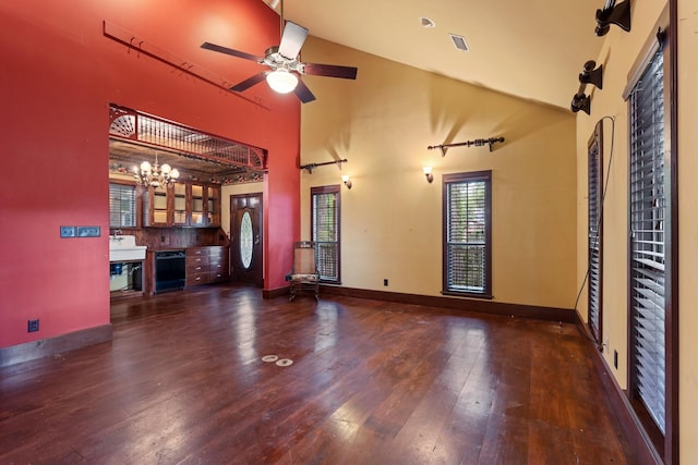 unfurnished living room featuring high vaulted ceiling, baseboards, hardwood / wood-style flooring, and ceiling fan with notable chandelier