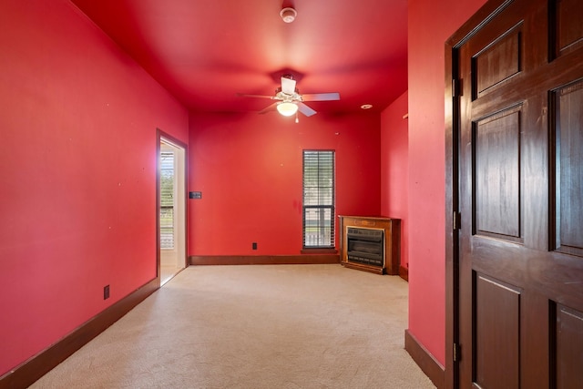 unfurnished living room with baseboards, carpet flooring, a fireplace, and ceiling fan