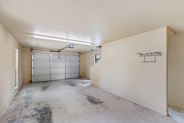 garage with a garage door opener and baseboards