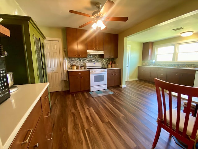 2027 103rd St, Galveston, TX 77554 - kitchen with visible vents, light countertops, under cabinet range hood, white gas stove, and backsplash