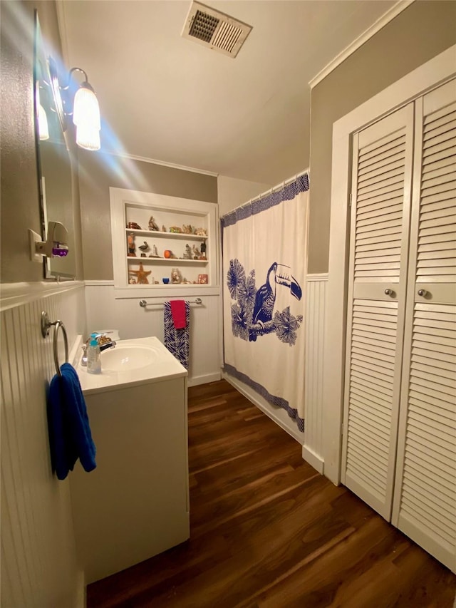 2027 103rd St, Galveston, TX 77554 - full bathroom with visible vents, wainscoting, wood finished floors, and vanity